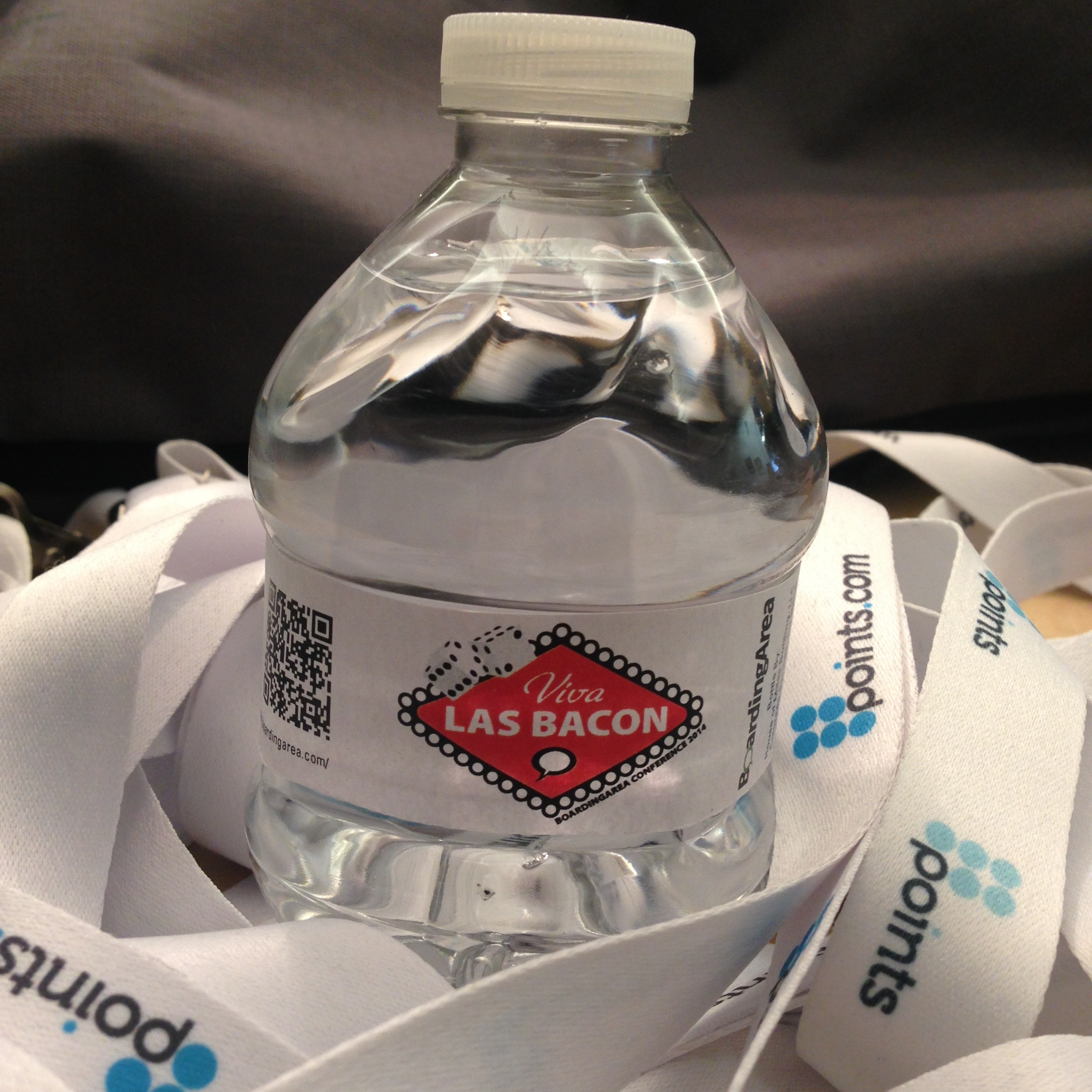 a bottle of water on a white ribbon